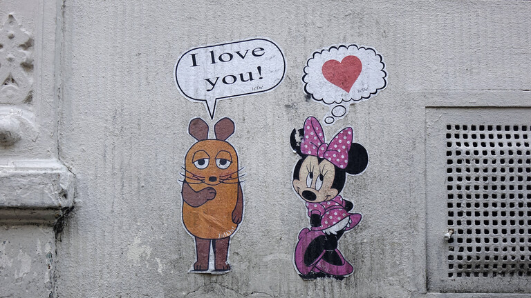 Graffito in Köln: Maus (von der Sendung mit der Maus) mit Sprechblase "I love you", daneben Minnie Maus (Disney) mit Herz in Gedankenblase