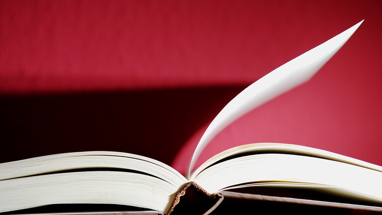 Ein aufgeschlagenes Buch. Eine Seite steht ab.