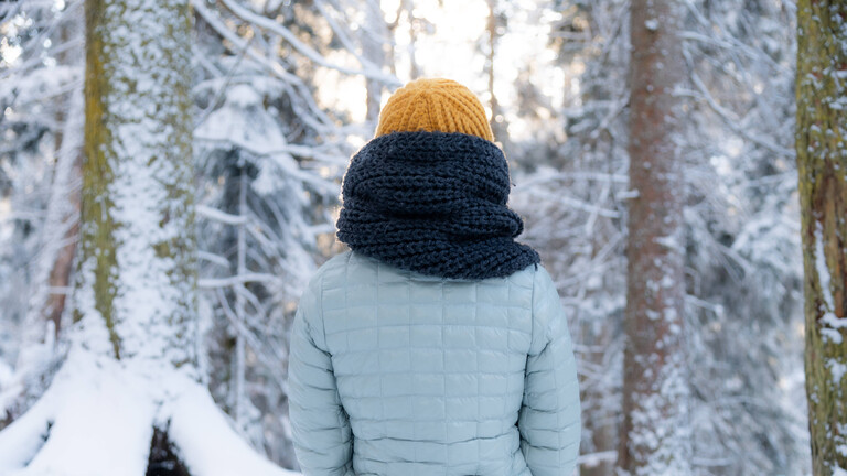 Eine Frau geht einen verschneiten Weg entlang