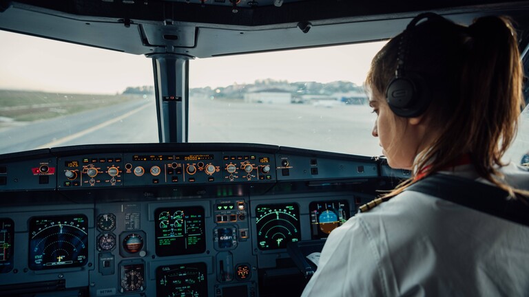 Eine Pilotin sitzt im Cockpit eines Flugzeugs