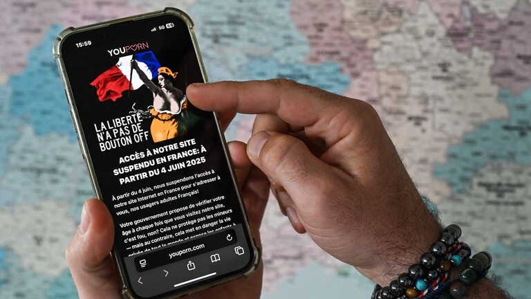 Eine Person hält ein Smartphone in der Hand, auf dem die Seite "Pornhub" geöffnet ist