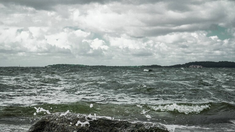 Stürmische See und Wellen treffen auf einen großen Felsen vor einer Meereskulisse. Stein in den Wellen der Ostsee.