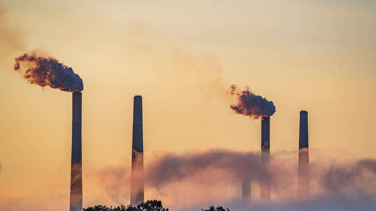 Rauchende Schornsteine im Sonnenuntergang