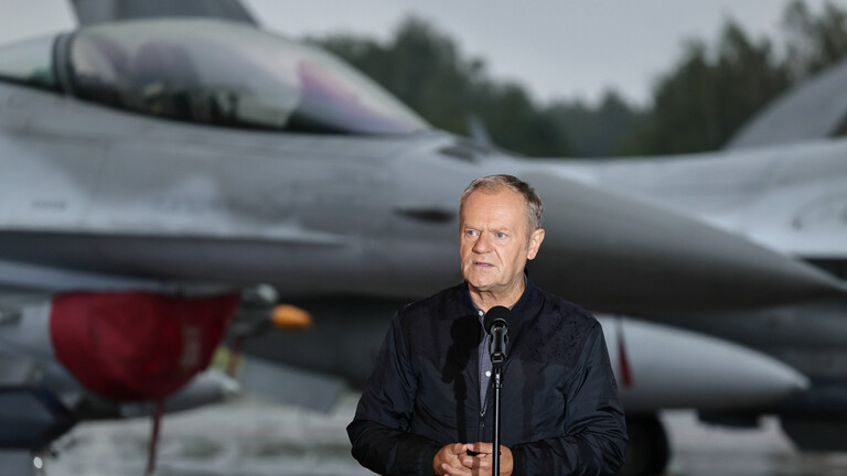 Polens Ministerpräsident Donald Tusk steht vor einem polnischen Kampfflugzeug