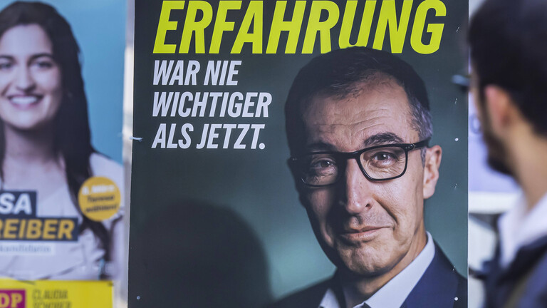 Mann schaut auf ein Wahlplakat mit Özdemir