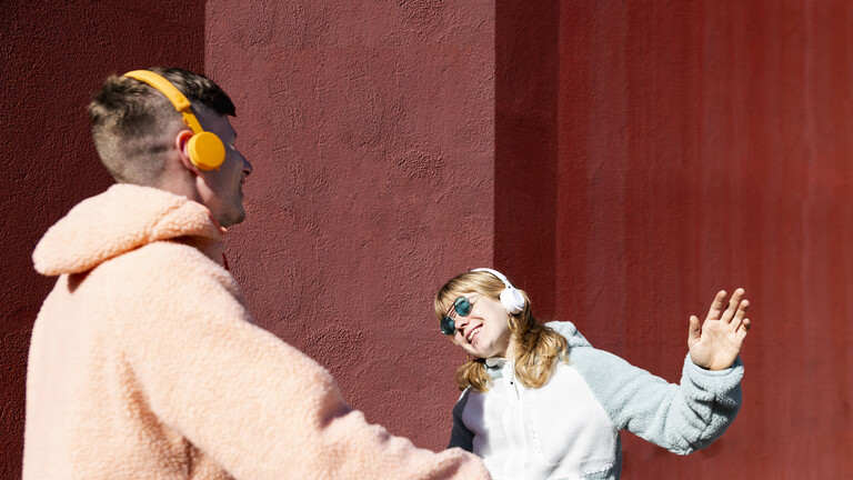 Ein Mann und eine Tanzen und haben Kopfhörer auf.