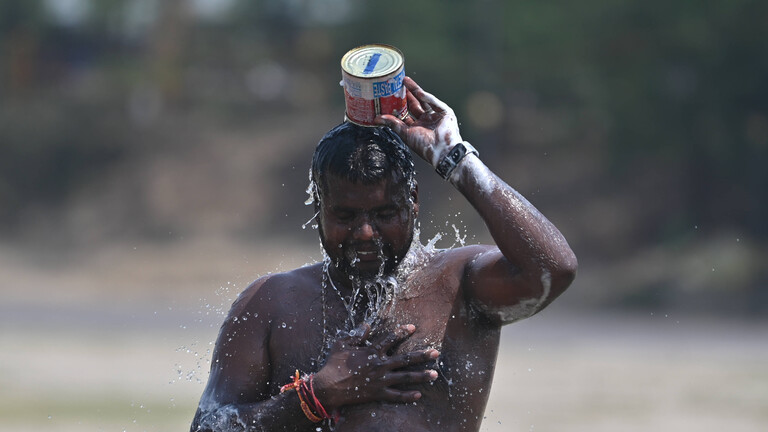 Ein Mann in Indien überschüttet sich mit Wasser