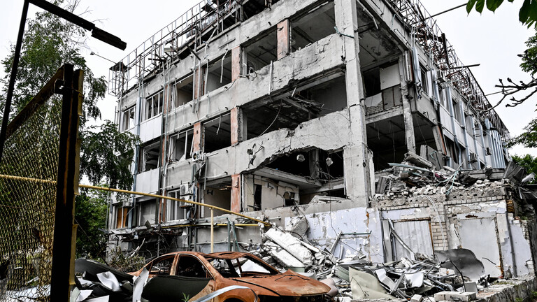Durch russische Angriffe zerstörtes mehrstöckiges Wohnhaus und ausgebranntes rotes Autowrack (10.06.2026)