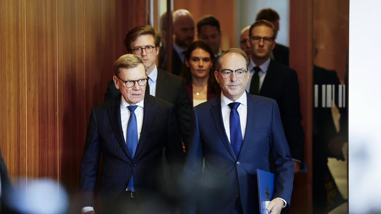 Vor einem Pressestatement kommen Johann Wadephul (l.), Bundesaußenminister, und Alexander Dobrindt, Bundesinnenminister, in den Raum hinein. Es geht um die Drohnenattacke am Flughafen von Leipzig.