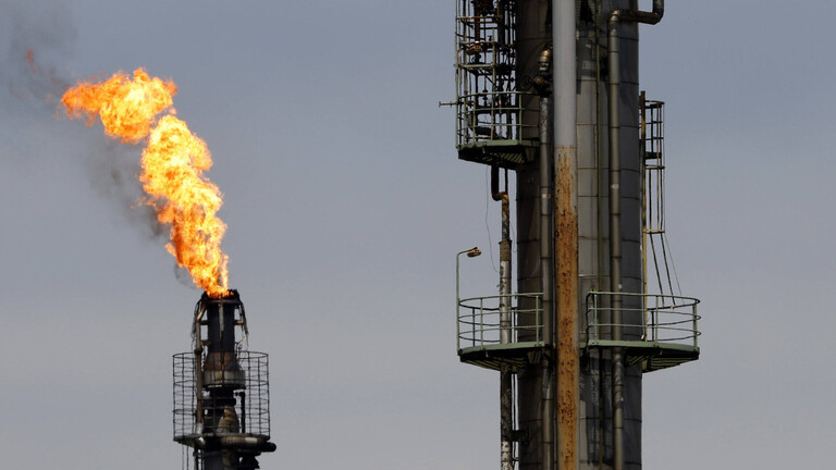 Foto von vier Hochfackeln, eine davon brennend,  an der Rheinland Raffinerie des Öl- und Gas-Konzern Shell am Standort in Wesseling bei Köln