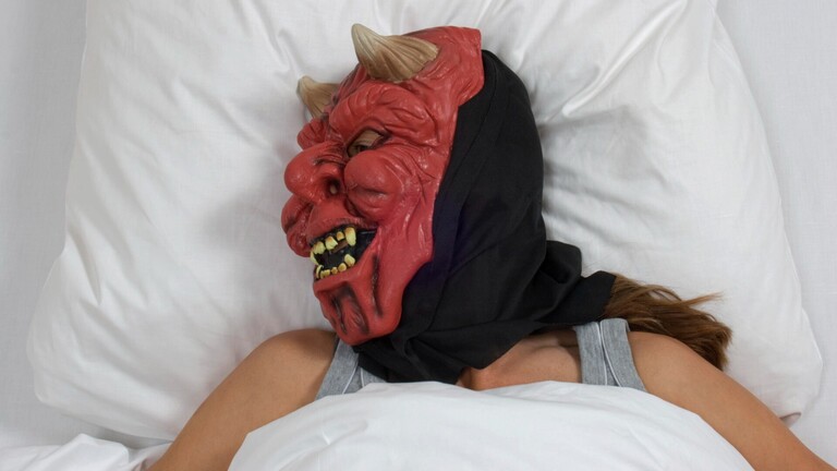 Schlafende Frau mit Teufelsmaske
