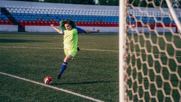 Eine Frau schießt gegen einen Fußball
