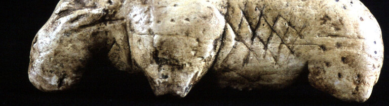 In eine Tierfigur aus der Steinzeit sind Punkte und Kreuze eingeritzt. Die Figur stammt aus der schwäbischen Vogelherdhöhle.