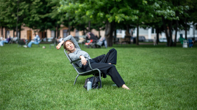Eine Frau beim Mittagsschlaf auf einer Wiese.