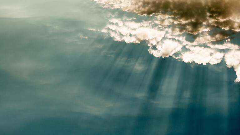 Wolken vor blauem Himmel mit spektakulärem Licht der Sonnenstrahlen.