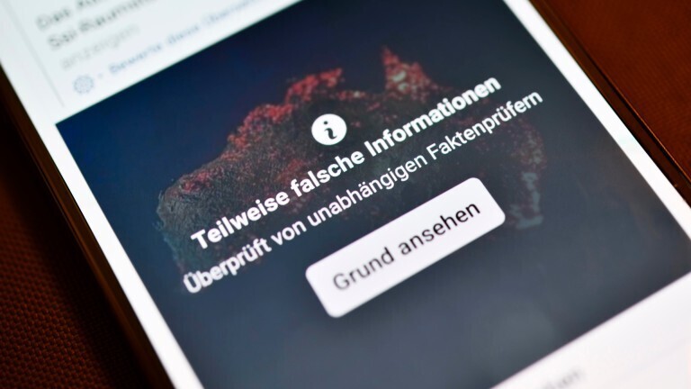 Smartphone mit aufgedeckter Falschinformation in einem sozialen Netzwerk