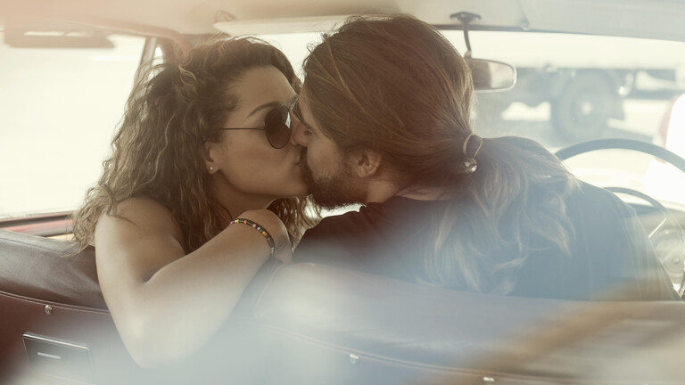 Ein Paar küsst sich im Auto