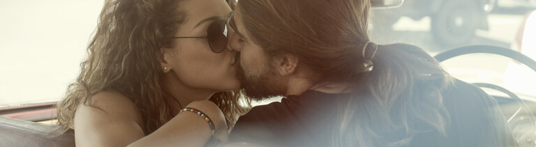 Ein Paar küsst sich im Auto