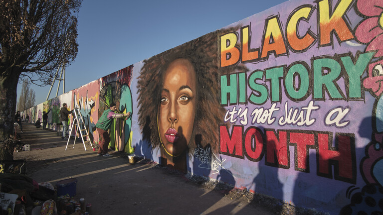 Graffitikünstler Eme Freethinker sprüht das Portrait einer schwarzen Frau an eine Wand am Mauerpark in Berlin. Zu lesen sind die Worte: Black History - it's not just a - Month,