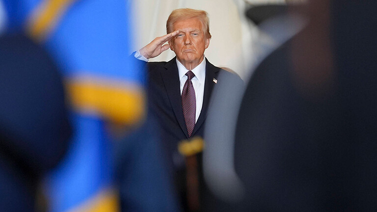 Links und rechts stehen Personen in Uniform. Zwischen ihnen ist eine Lücke. Der Blick fällt durch die Lücke auf US-Präsident Trump, der salutiert. Es ist die Amtseinführung von Trump am 20.01.2025.