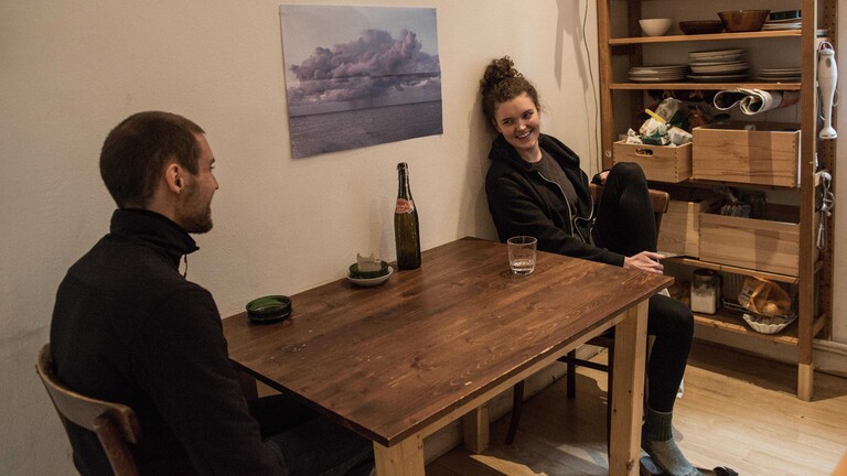 Lea (r), Studentin an der Hochschule Hannover, spricht in der Küche ihrer Studenten-WG mit ihrem Mitbewohner Luis.