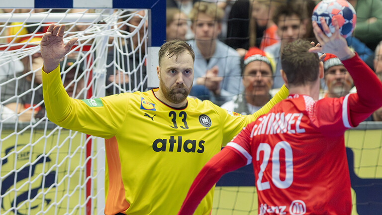 Handball-EM: Torwart Andreas Wolff steht im Tor, er hat die Arme oben. Vor ihm steht ein dänischer Spieler für einen Siebenmeter. Er hat den linken Arm oben mit dem Ball in der Hand.