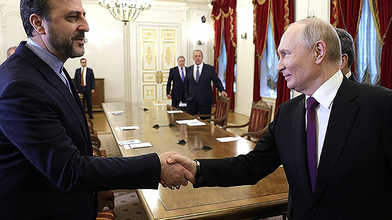 In Petersburg bei einem Treffen schütteln sich der iranische Außenminister Araghtschi und der russische Präsident Putin die Hände.