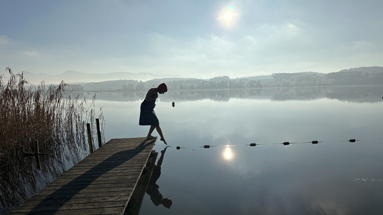 Reisejournalistin Julia Finkernagel steckt ihre nackten Füße in einen Bergsee