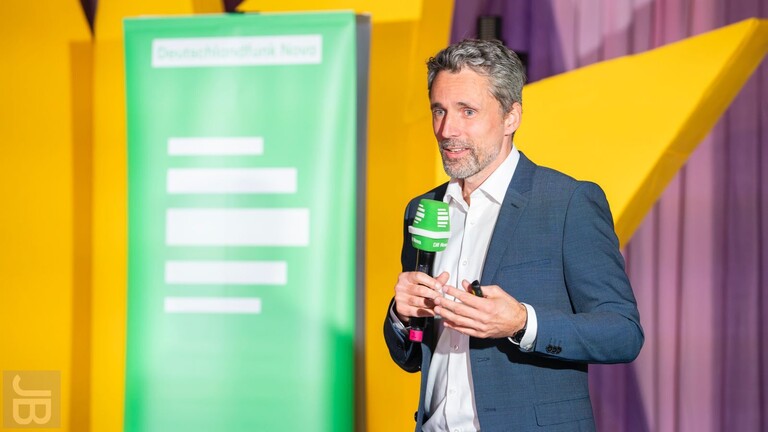 Der Informatiker Tim Landgraf hält seinen Vortrag "Vom Bienenstock zu Skynet: Wie KI unsere kollektive Intelligenz verändert" für den Deutschlandfunk-Nova-Podcast 'Hörsaal' im Rahmen des Silbersalz Science & Media Festivals 2025