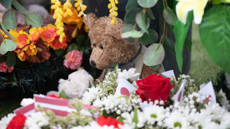 Zum Gedenken der Opfer des Massakers in Butscha wurden Blumen und ein Teddy-Bär niedergelegt.