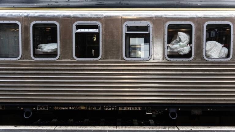 Kissen und Decken vor den Fenstern eines Nachtzuges