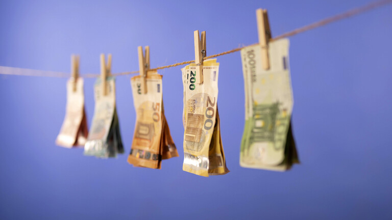Geldscheine hängen auf einer Wäscheleine zum Trocknen