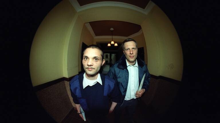 Symbolbild: Blick durch den Türspion zeigt zwei Vertreter, die vor einer Haustür stehen