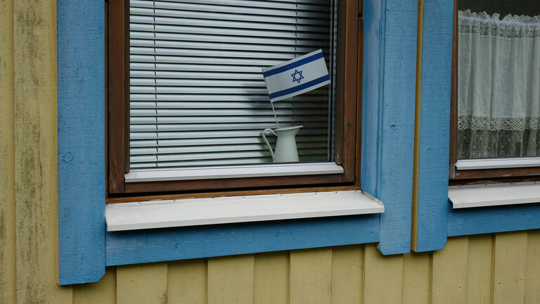 Ein Krug mit einer israelischen Fahne in einem Fenster