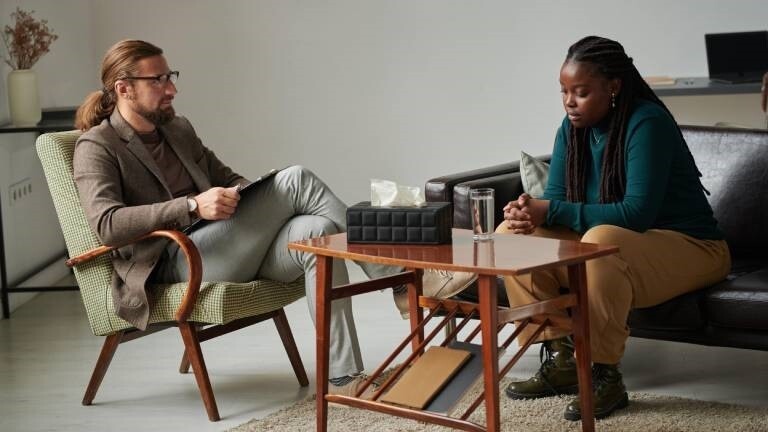 Eine Frau befindet sich in einer Sitzung mit einem Therapeuten