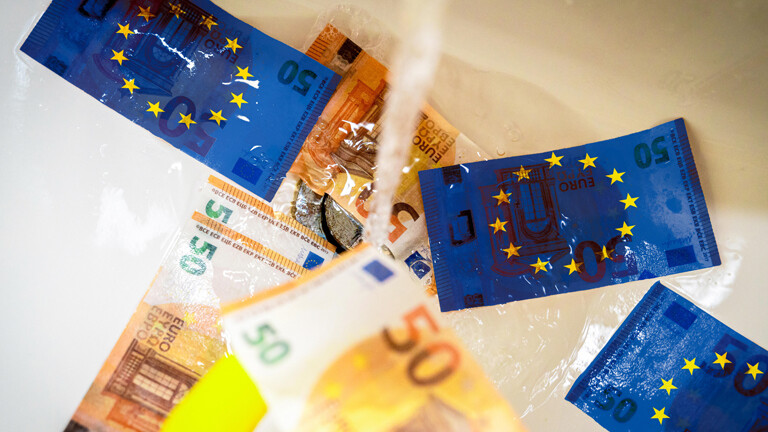 Im Waschbecken läuft der Wasserhahn, Person wäscht Geld. Auf den Geldscheinen die EU-Fahne. (Fotomontage)