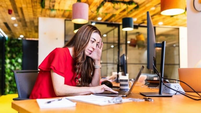 Eine junge Frau sitzt am Schreibtisch in einem Büro