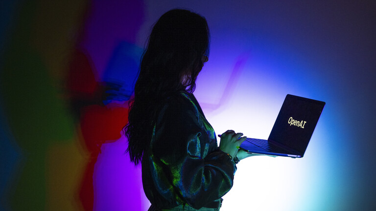 Auf dem Laptop einer Frau ist das Logo von OpenAI zu sehen