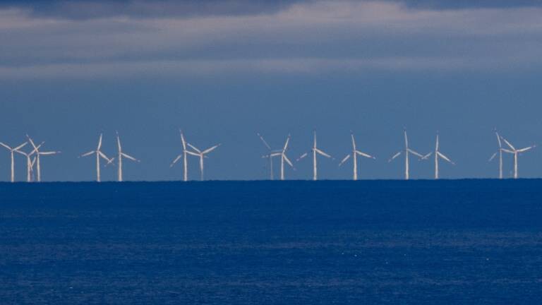 Ein Schiff fährt vor dem Windpark Baltic Eagle auf der Ostsee vor der Insel Rügen (Landkreis Vorpommern-Rügen) entlang.