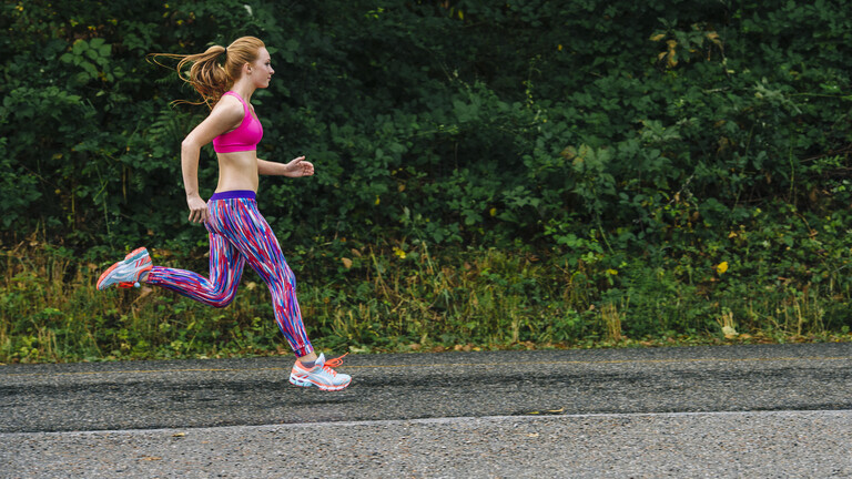 Eine Joggerin joggt auf Asphalt