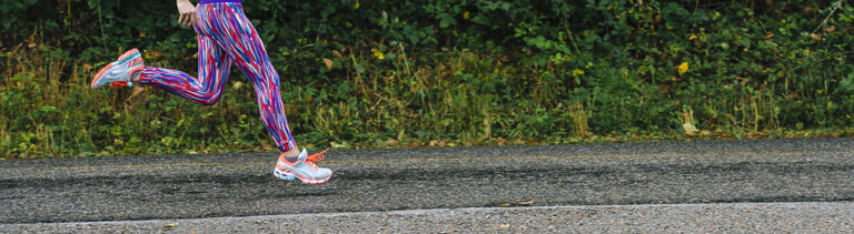 Eine Joggerin joggt auf Asphalt