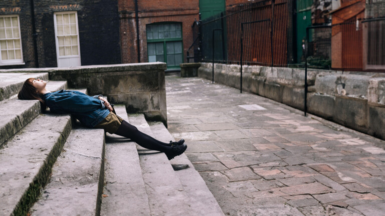 Junge Frau liegt auf Treppe