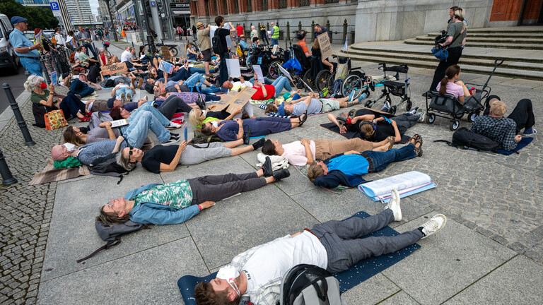 Demonstranten haben sich vor dem Roten Rathaus für fünf Minuten zu einer Liegend-Demo auf den Boden gelegt.