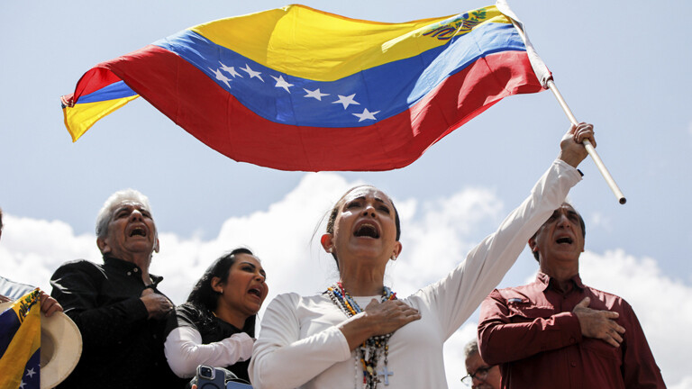 Oppositionsführerin María Corina Machado schwenkt eine venezolanische Nationalflagge während einer Kundgebung in Caracas, Venezuela, am Samstag, dem 17. August 2024, um gegen das offizielle Wahlergebnis zu protestieren, das Präsident Nicolás Maduro zum Sieger der Juli-Wahl erklärte.