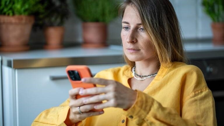 Eine Frau hält ein Smartphone in der Hand