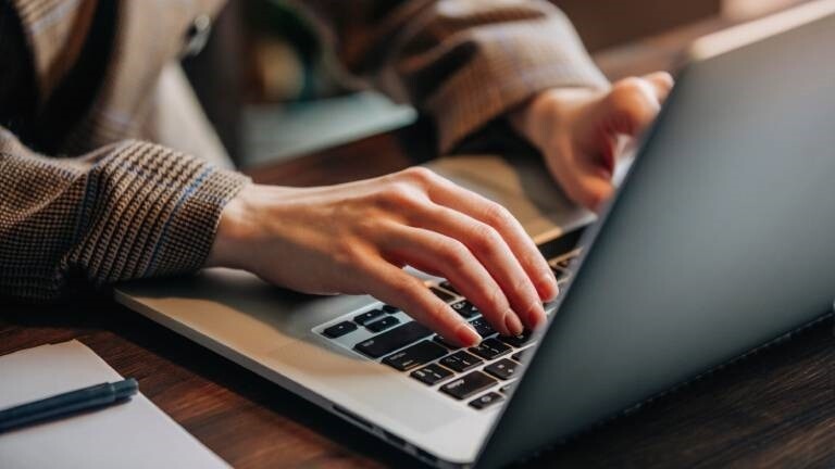 Eine Frau tippt auf einem Laptop