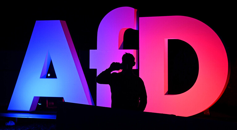 Ein Mann telefoniert bei der Wahlparty der AFD in der AfD Bundesgeschäftsstelle vor dem Logo der Partei. Am Sonntag fand die vorgezogene Wahl zum 21. Deutschen Bundestag statt.