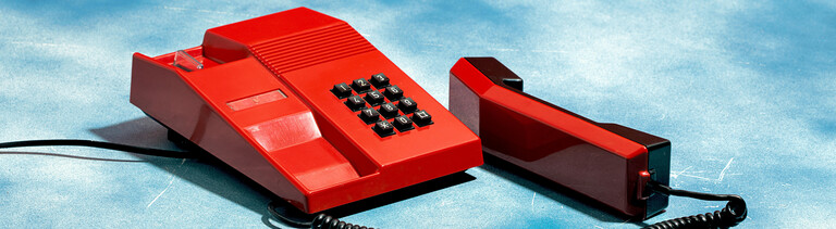 Altes rotes Telefon auf einem Wolkenhimmel-Hintergrund