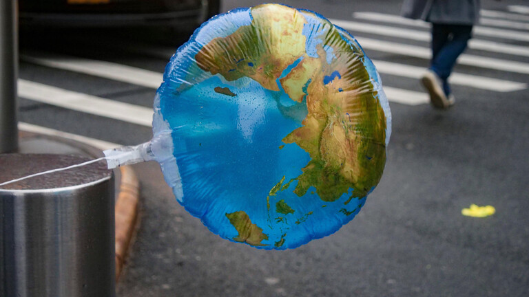 Ein Luftballon mit einer Weltkarte weht im Wind