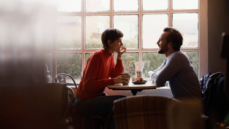 Eine Frau und ein Mann sitzen in einem Café und unterhalten sich